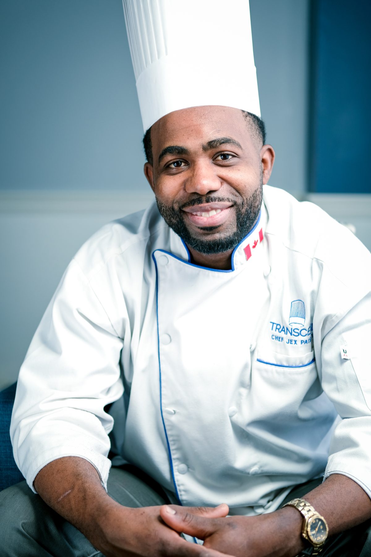 Chef in whites seated with hands clasped